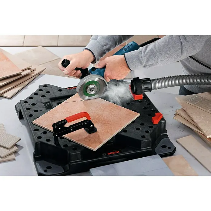 Bosch Professional Elektro-Winkelschleifer GWS 7-125 - 720 W, Durchmesser Scheibe: 125 mm, Leerlaufdrehzahl: 11.000 U/min - Der Bosch Fliesenschneider in Aktion: Präzises Schneiden von Fliesen mit Staubabsaugung für sauberes Arbeiten.