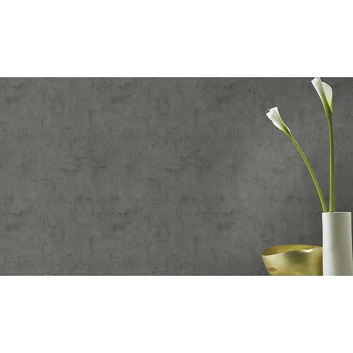 Rasch Tapetenwechsel Vliestapete - Dunkelgrau, Betonoptik, 10,05 x 0,53 m - Nahaufnahme eines grauen Hintergrunds mit zwei weißen Calla-Lilien in einer Vase und einer goldenen Schale.