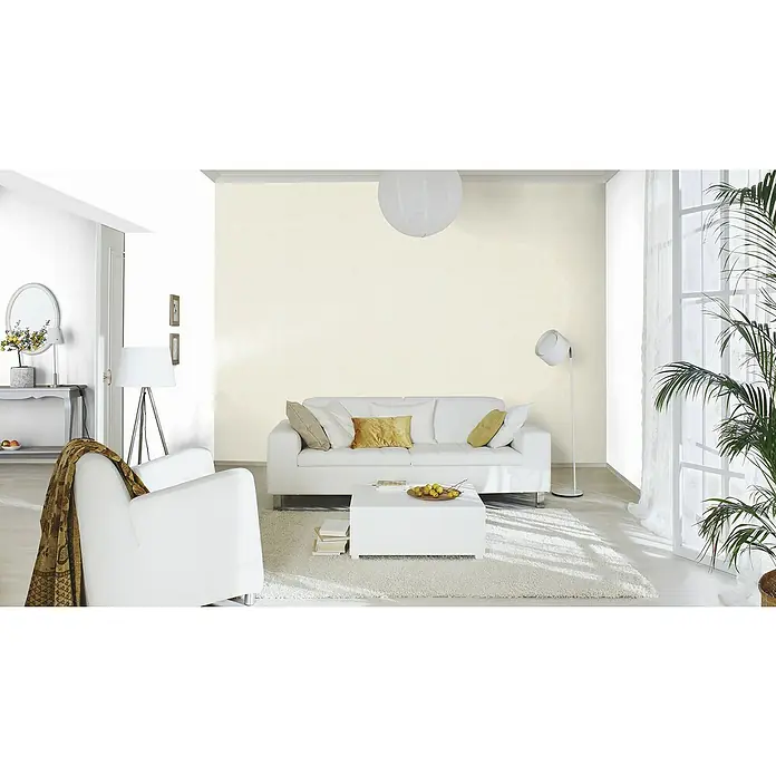 Rasch Kimono Vliestapete - Cremeweiß, Uni, 10,05 x 0,53 m - Ein helles Wohnzimmer mit einem weißen Sofa, Sessel und Teppich, ergänzt durch eine stilvolle Beleuchtung und Zimmerpflanze.