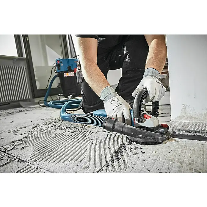 Bosch Professional Betonschleifer - 1.500 W, 9.300 U/min, Durchmesser Scheibe: 125 mm - Der Bosch Mauernutfräse mit Staubabsaugung im Einsatz bei Renovierungsarbeiten. Sauberes Arbeiten durch effiziente Staubentfernung.