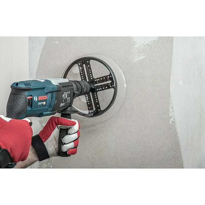 Craftomat Lochsäge Verstellbar - Verstellbar - Eine Bosch Schlagbohrmaschine mit Schleifteller wird zum Glätten einer Wand eingesetzt. Handschuhe schützen die Hände bei der Arbeit.