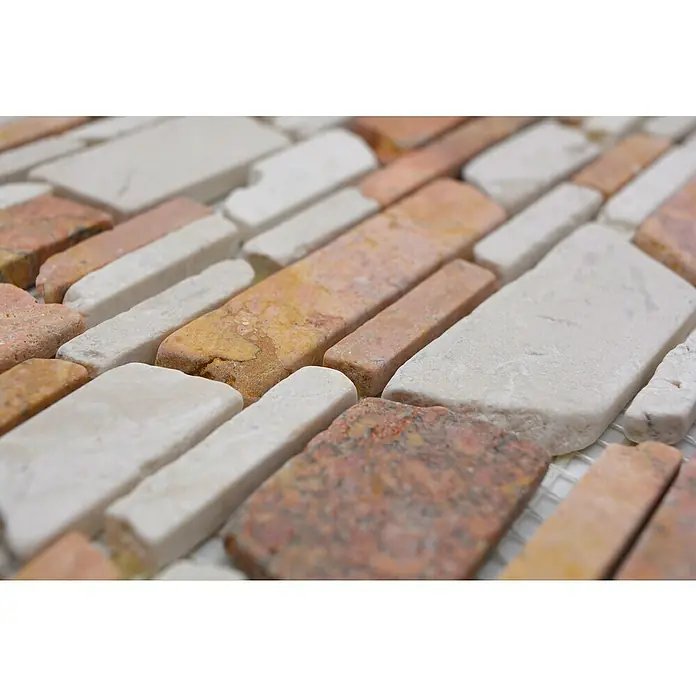 Mosaikfliese Mix MOS BRICK 225 - 30,5 x 30,5 cm, Rot/Weiß, Matt - Nahaufnahme von einer dekorativen Wandverkleidung aus Natursteinen in verschiedenen Farben und Größen, die ein rustikales Muster bilden.