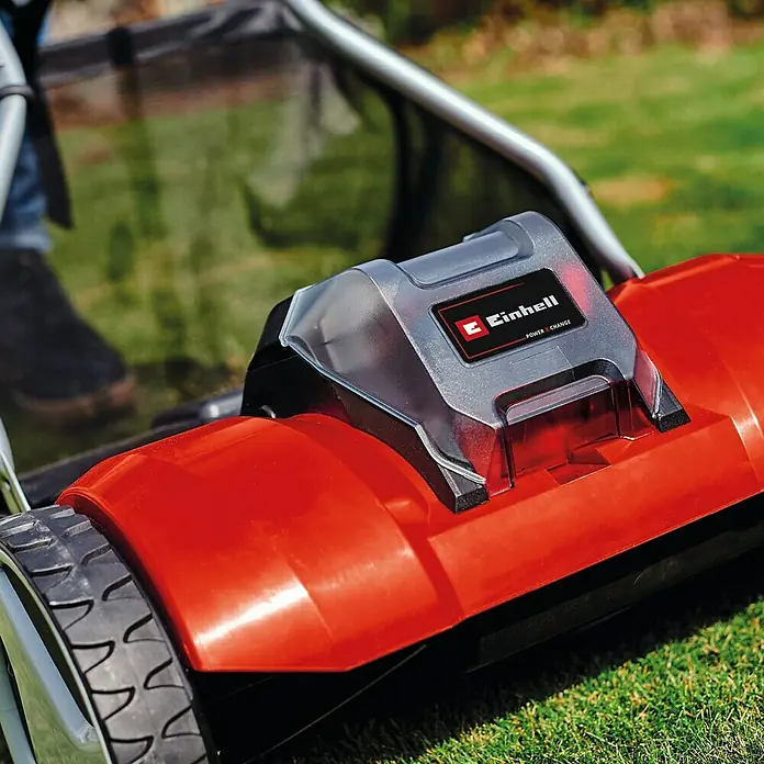 Einhell Power X-Change 18V Akku-Spindelmäher GE-HM 18/38 Li-Solo - 18 V, Ohne Akku, 4 Ah, Schnittbreite: 38 cm - Nahaufnahme eines roten Einhell Rasenmähers auf Rasen mit Akku-Pack. Ideal für präzise Rasenpflege und effizientes Mähen im Garten.