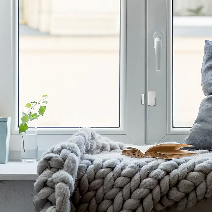 Avidsen Fenster- & Türsensor - Passend für: Avidsen Alarm-Kit Modell 100720 & 100731, Reichweite ca.: 100 m - Nahaufnahme eines Fensters mit einem Smart Home-Fenstersensor in Weiß, der Sicherheit und Komfort bietet.