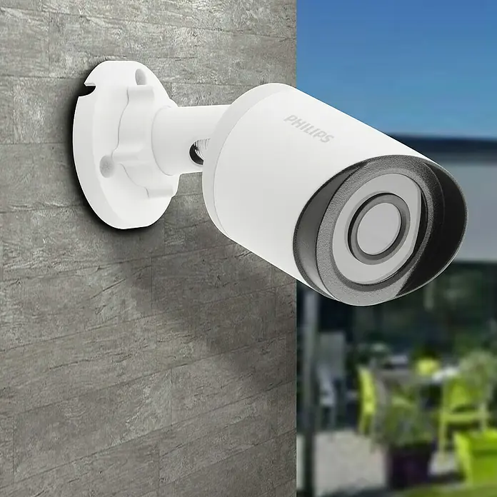 Philips WelcomeEye Überwachungskamera - Passend für: Philips Welcome Eye System, 75 ° - Nahaufnahme einer weißen Philips Überwachungskamera an einer grauen Wand, die Sicherheit und moderne Technologie vereint.
