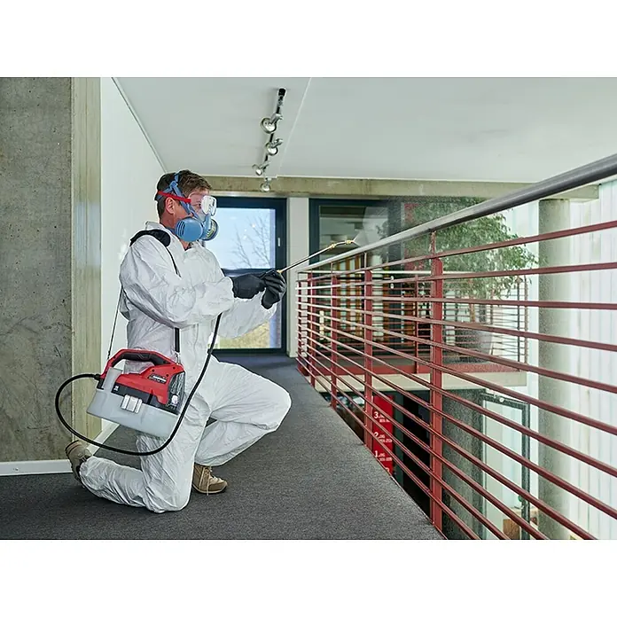 Einhell Power X-Change 18V Akku-Sprühgerät GE-WS 18/75 LI-SOLO - 18 V, Ohne Akku, Füllmenge: 7,5 l - Ein Mann im Schutzanzug sprüht mit einem rot-schwarzen Einhell Akku-Sprühgerät ein Geländer. Schutz ist bei solchen Arbeiten wichtig.