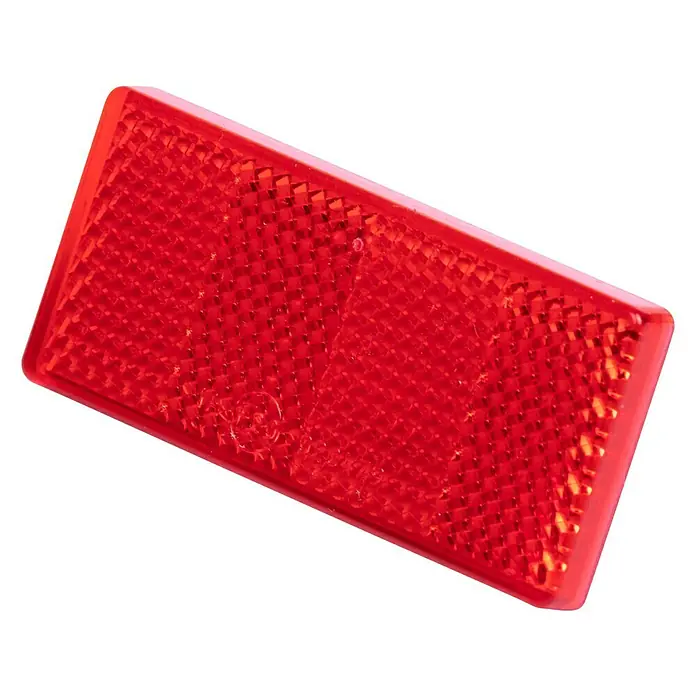 Stema Reflektor - 69 x 31,5 mm - Nahaufnahme eines roten rechteckigen Rückstrahlers, der für bessere Sichtbarkeit im Dunkeln sorgt. Das reflektierende Material ist geriffelt.