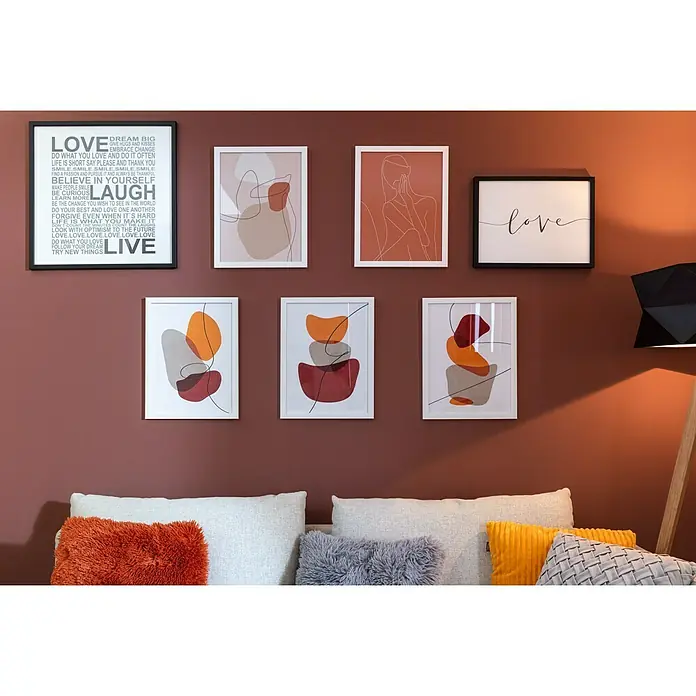 Bild - Abstrakt Frau, B x H: 30 x 40 cm, 2 -tlg. - Eine Wand mit sieben gerahmten Kunstdrucken in verschiedenen Größen und Stilen, die über einem Sofa mit Kissen angeordnet sind.