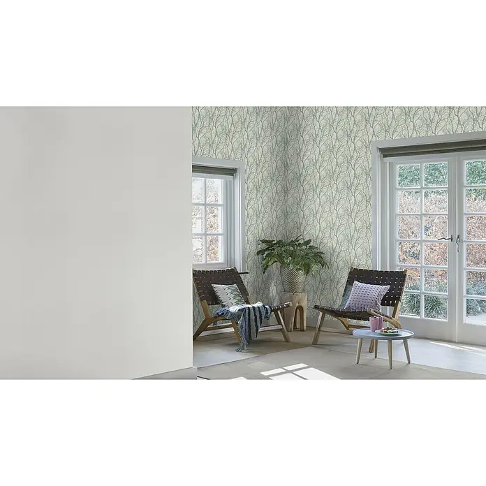 Rasch Vliestapete Deco Style - Grau/Silber/Schwarz, Uni, 10,05 x 0,53 m, Feine Struktur - Einladender Raum mit zwei eleganten Sesseln, einem Beistelltisch und einer stilvollen Wand mit Baummuster-Tapete.