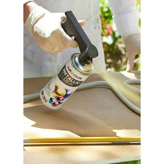 Dupli-Color Sprühhilfe Spraymaster - Kunststoff - Nahaufnahme einer Person, die mit Dupli-Color Metallic Look Farbspray eine Metallstange besprüht, wobei der Fokus auf dem Produkt liegt.