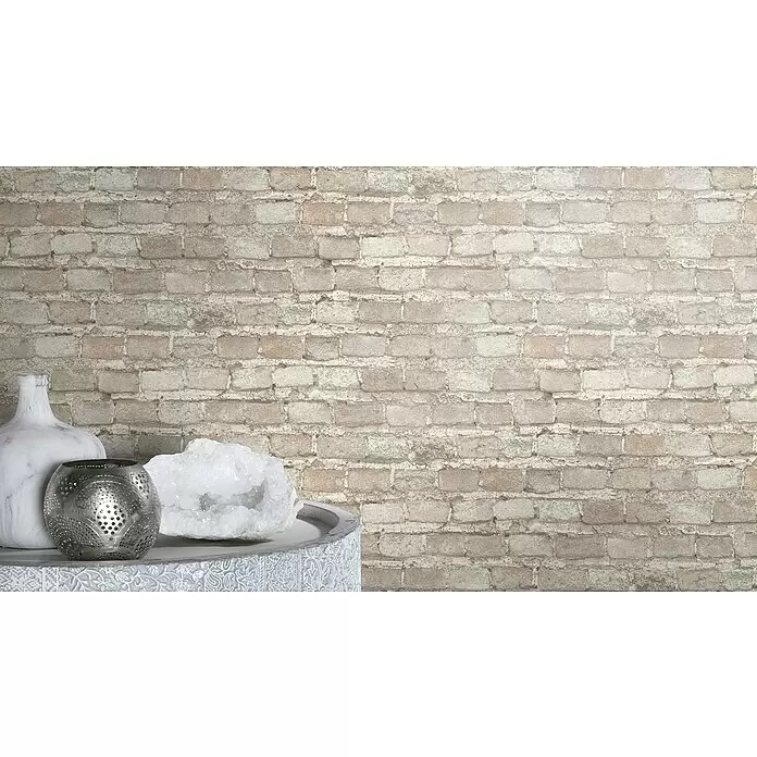Rasch Factory 4 Vliestapete Steinmauer - Weiß, Steinoptik, 10,05 x 0,53 m - Rustikale hellfarbene Backsteinwand mit Dekoartikeln: eine Marmorvase, ein silberner Kerzenhalter und Kristall auf einem Tisch.