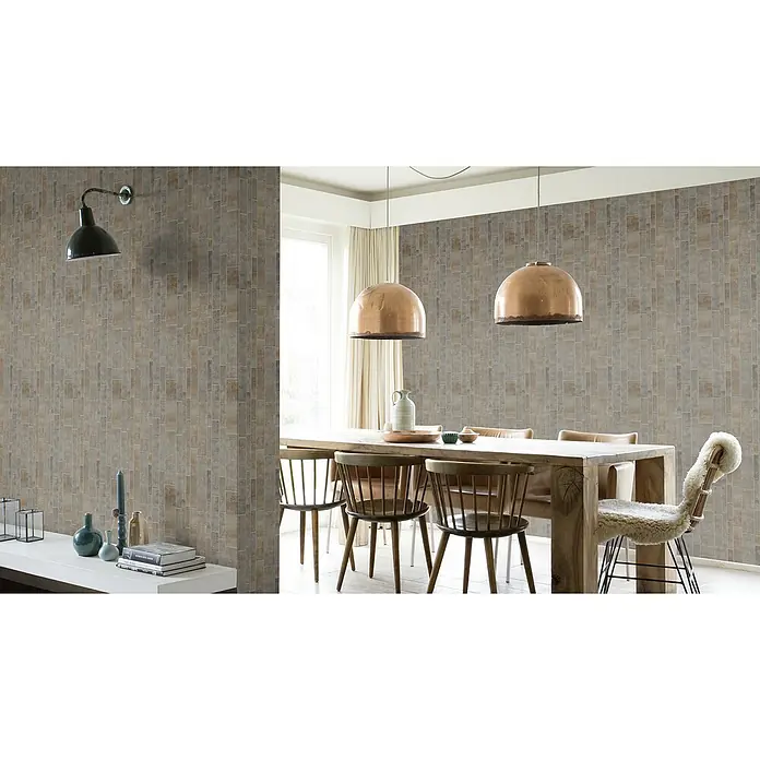 Rasch Factory 4 Vliestapete Fliesen - Grau, Fliesenoptik, 10,05 x 0,53 m - Ein Speisezimmer mit einem Holztisch und Kupferleuchten unter der Decke. Die Wände sind mit einem Backsteinmuster versehen.