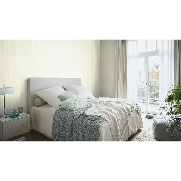 Rasch Saphira Vliestapete Streifen - Hellbeige, Streifen, 10,05 x 0,53 m - Einladendes Schlafzimmer mit hellem Bett, weichen Kissen, Decken und einem Nachttisch mit Lampe. Die sanften Farben schaffen eine entspannende Atmosphäre.