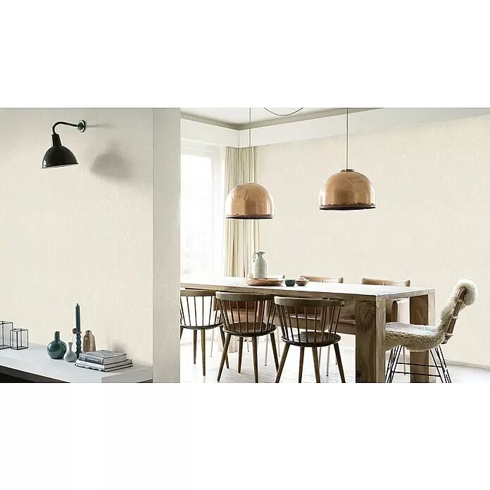 Rasch Factory 4 Vliestapete - Creme, Uni, 10,05 x 0,53 m - Cremefarbene, strukturierte Tapete an den Wänden eines Esszimmers mit Holzmöbeln und Kupferpendelleuchten.