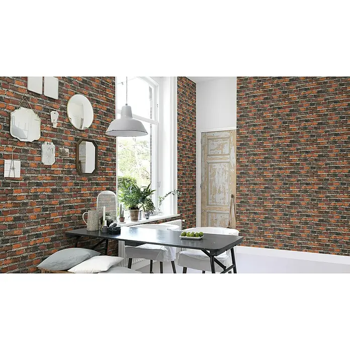 Rasch Factory 4 Vliestapete Steinmauer - Rotbraun, Steinoptik, 10,05 x 0,53 m - Esszimmer mit auffälliger Backsteintapete, Spiegeln an der Wand und einem Esstisch in der Mitte des Raumes für ein modernes Ambiente.