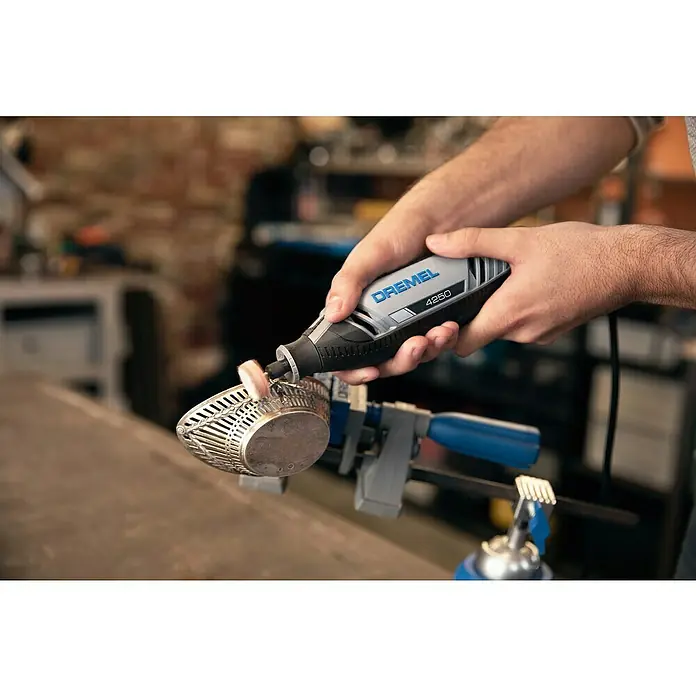 Dremel Multifunktionswerkzeug 4250-35 - 175 W, 5.000 U/min - 35.000 U/min - Detailaufnahme eines Dremel 4250 Multifunktionswerkzeugs in Aktion, das ein Metallobjekt poliert und die Präzision und Vielseitigkeit des Werkzeugs hervorhebt.