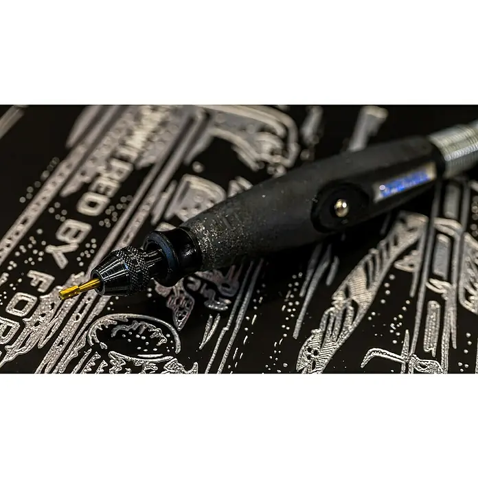 Dremel Fräsmesser Max 194DM - 2 Stk. - Ein kabelloser Rotationswerkzeug mit einer goldenen Spitze liegt auf einer schwarzen Oberfläche. Das Werkzeug ist für Präzisionsarbeiten konzipiert.