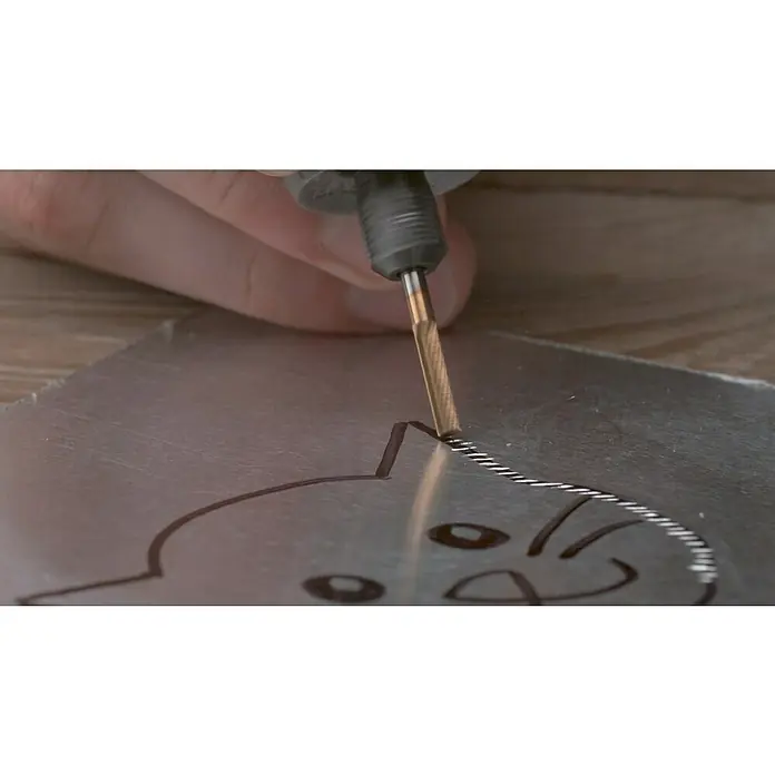 Dremel Fresa de alta velocidad 9901DM - Diámetro de trabajo: 3,2 mm, Plano - Primer plano de una fresadora de precisión que graba un diseño de gato en una placa de metal, destacando los detalles intrincados del proyecto.