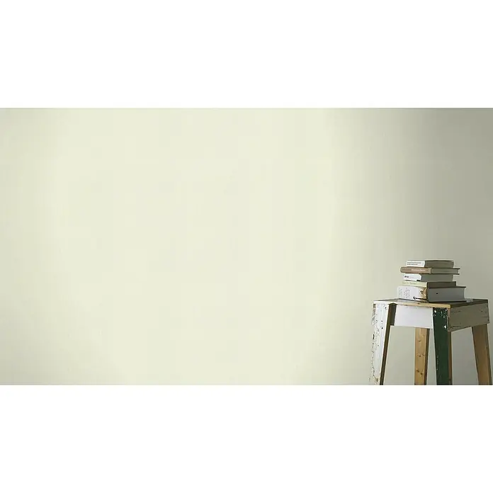 FREUNDIN HOME COLLECTION III Vliestapete II - Creme, Uni, 10,05 x 0,53 m - Bücher auf einem Hocker gestapelt. Der Hocker ist bemalt und die Bücher sind verschiedener Größe. Wand im Hintergrund.