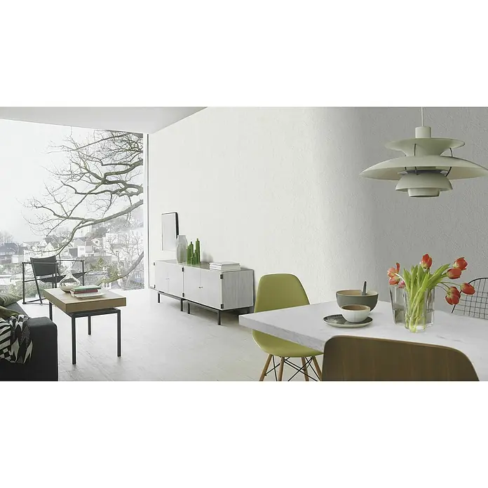 Rasch Vliestapete Putzstruktur II - Weiß, Uni, 10,05 x 0,53 m - Ein stilvolles Wohnzimmer mit einer Kommode, einem Esstisch mit Stühlen und einer dekorativen Lampe, die eine moderne Atmosphäre schafft.