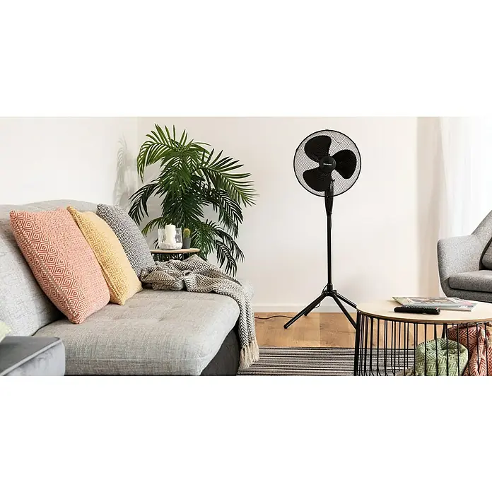 Voltomat Standventilator - Schwarz, 40 cm, 125 cm - Das Bild zeigt einen schwarzen Standventilator in einem modernen Wohnzimmer. Der Ventilator steht auf einem Holzboden neben einem Couchtisch.