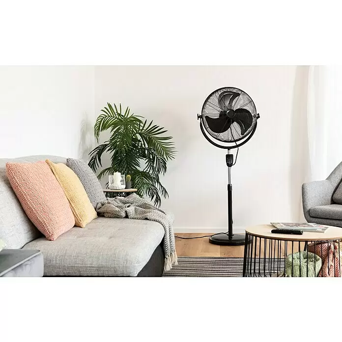 PR Klima Ventilador de pie Speed II - Negro, 45 cm, 135 cm - Un ventilador de pie negro con rejilla circular y aspas, sobre un poste plateado y negro en una sala de estar moderna.