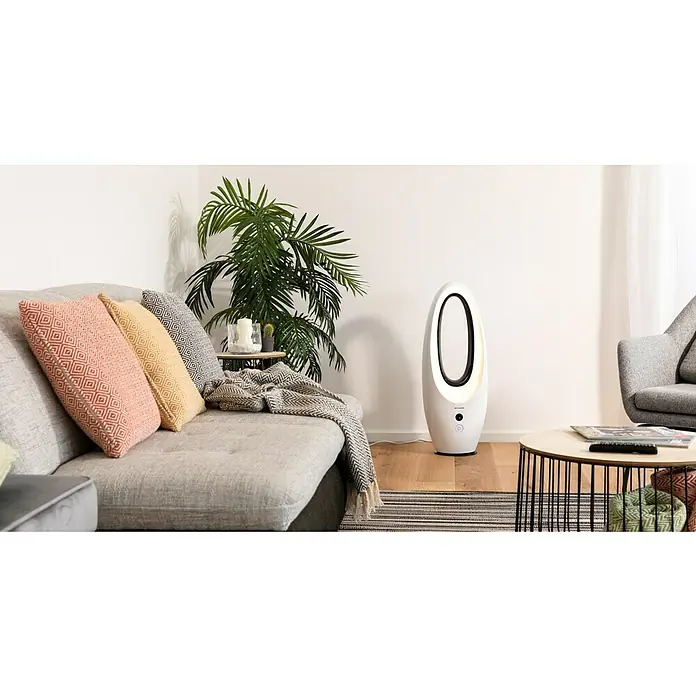 Voltomat Ventilador de torre Design - Blanco, 80 cm, 65 W - La imagen muestra un moderno ventilador de torre blanco en una sala de estar, colocado junto a un sofá, asegurando un ambiente fresco y agradable.