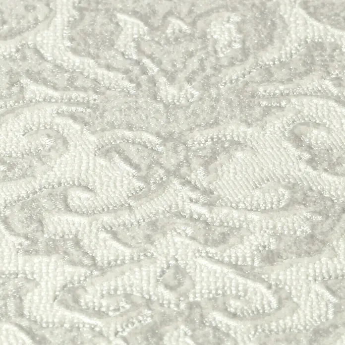 Rasch Saphira Vliestapete Barockornament - Weiß, Ornament, 10,05 x 0,53 m - Detailaufnahme von strukturiertem, elfenbeinfarbenem Samtstoff mit floralen Mustern. Die Textur und das Muster sind gut erkennbar.