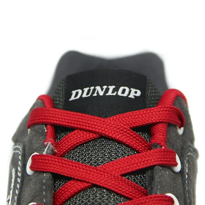 Dunlop Zapato bajo de seguridad Flying Luka - 36, Clase de protección según EN ISO 20345: S3, Gris/Rojo - Primer plano de una zapatilla Dunlop con cordones rojos y el logotipo Dunlop en la lengüeta. Comodidad y estilo en un solo zapato.