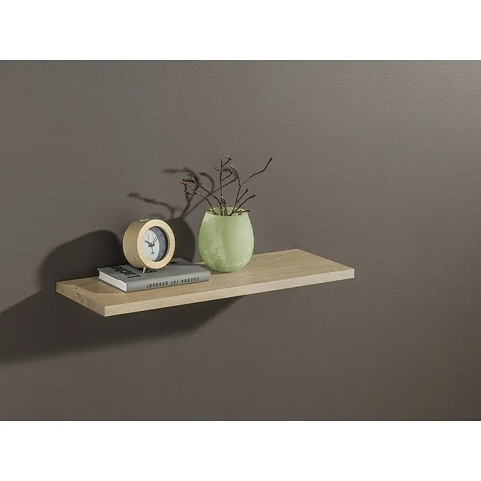 Dolle Wandboard Lite - L x B x S: 60 x 15 x 1,9 cm, Farbe: Eiche - Nahaufnahme eines Wandregals mit einer Uhr, einem Buch und einer Vase mit Zweigen vor einem grauen Hintergrund.