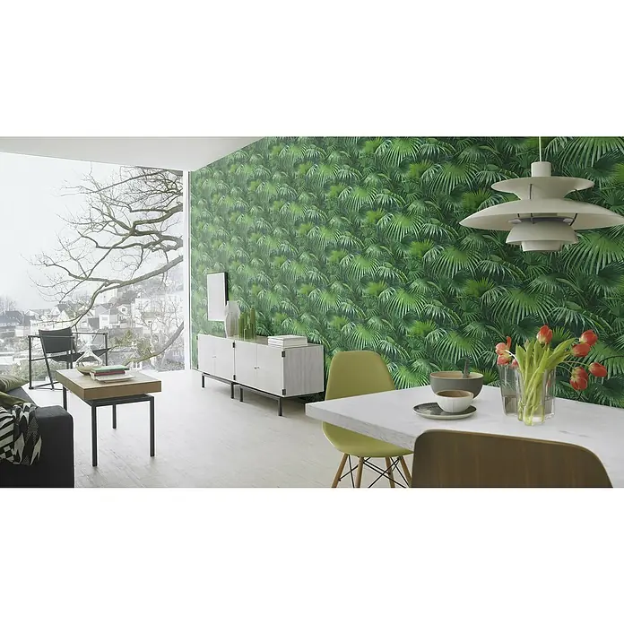 Rasch Crispy Paper Vliestapete Dschungel - Grün, Floral, 10,05 x 0,53 m - Innenaufnahme eines modern eingerichteten Wohnzimmers mit Palmenmustertapete und minimalistischen Möbeln.