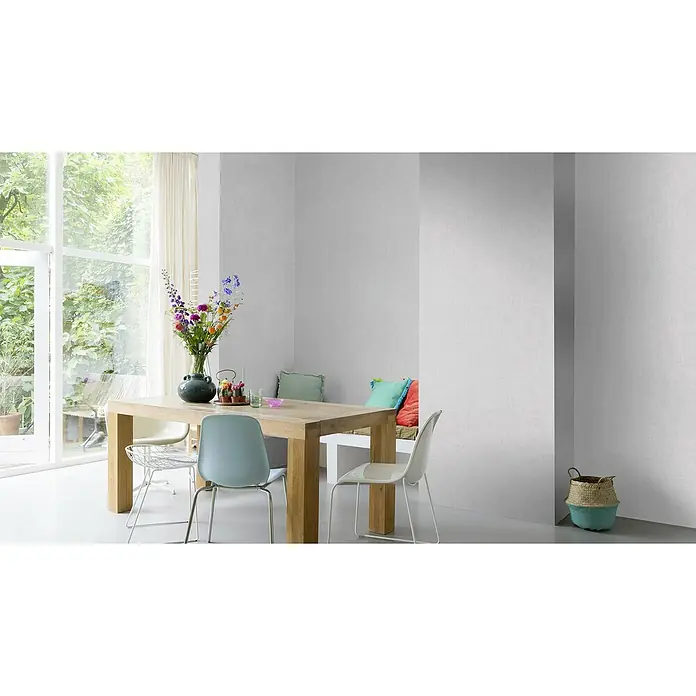 Rasch Vliestapete - Hellgrau, Uni, 10,05 x 0,53 m, Schimmernd - Helles Esszimmer mit einem Holztisch, umgeben von Stühlen, und einem Fenster mit Blick ins Grüne. Eine Blumenvase steht auf dem Tisch.
