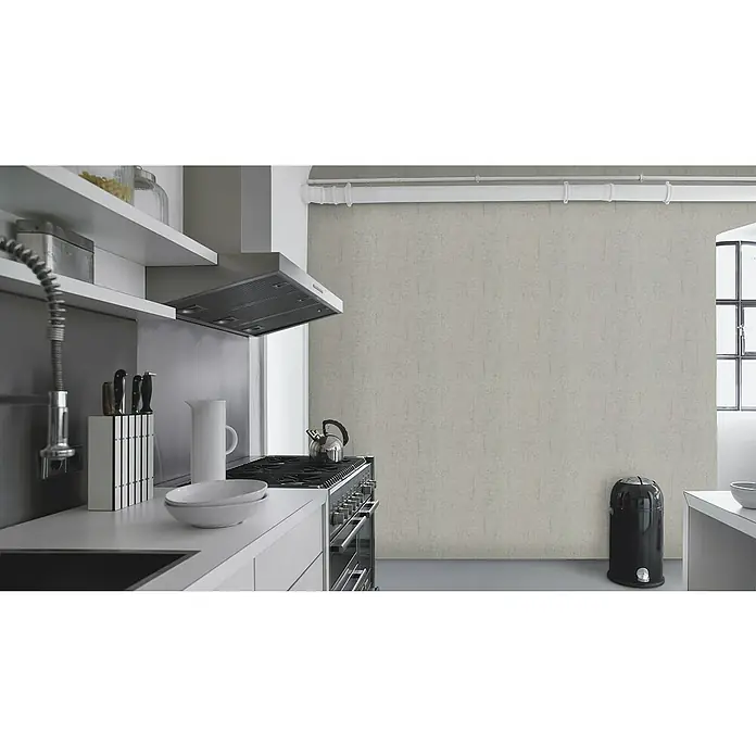 Rasch Vliestapete Beton - Hellgrau, Betonoptik, 10,05 x 0,53 m - Eine stilvolle Küche mit weißen Regalen, einer Dunstabzugshaube und einem modernen Herd, die ein minimalistisches und funktionales Design zeigt.