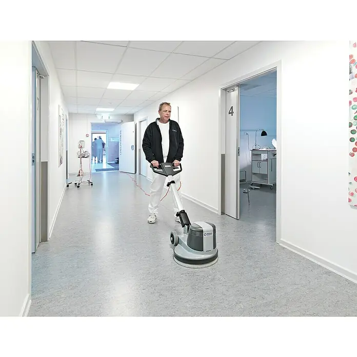 Nilfisk Poliermaschine FM400 D - 1.500 W - Ein Mann bedient eine Nilfisk-Reinigungsmaschine in einem Krankenhausflur, um Sauberkeit und Hygiene zu gewährleisten.