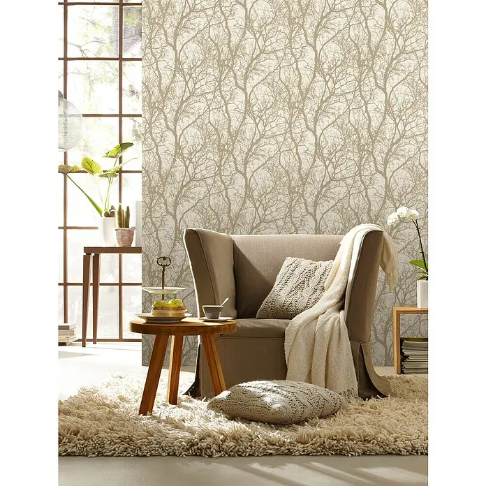 Rasch Tapetenwechsel Vliestapete Äste - Beige/Bronze, Floral, 10,05 x 0,53 m - Gemütlicher Lesesessel mit Kissen und Decke auf einem flauschigen Teppich. Einladende Atmosphäre mit Beistelltisch und Dekoration.