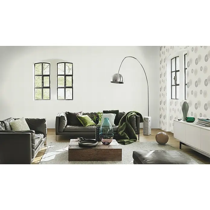 Rasch Tapetenwechsel Vliestapete I - Grau, Uni, 10,05 x 0,53 m - Ein stilvolles Wohnzimmer mit einer eleganten Couch, einem modernen Lampenbogen und einem hellen Teppich, der eine gemütliche Atmosphäre schafft.