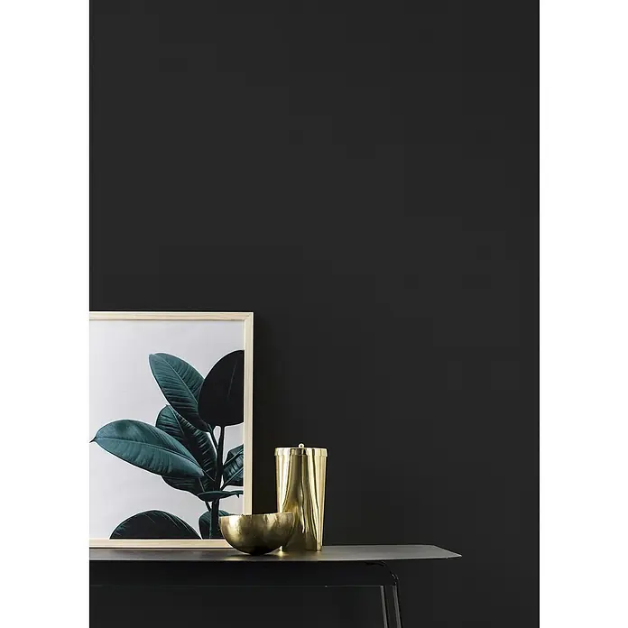 Rasch Kids & Teens III Vliestapete - Schwarz, Uni, 10,05 x 0,53 m - Das elegante Stillleben zeigt goldene Dekoschale & Dose neben einem gerahmten Pflanzenbild auf einem schwarzen Tisch vor dunkler Wand.
