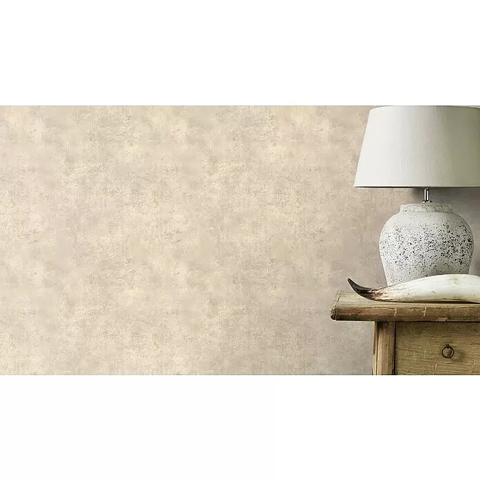 Rasch Vliestapete Beton - Braun, Betonoptik, 10,05 x 0,53 m - Eine hellbeige, strukturierte Wand mit rustikalem Tisch, Lampe und Deko-Horn auf der rechten Seite.