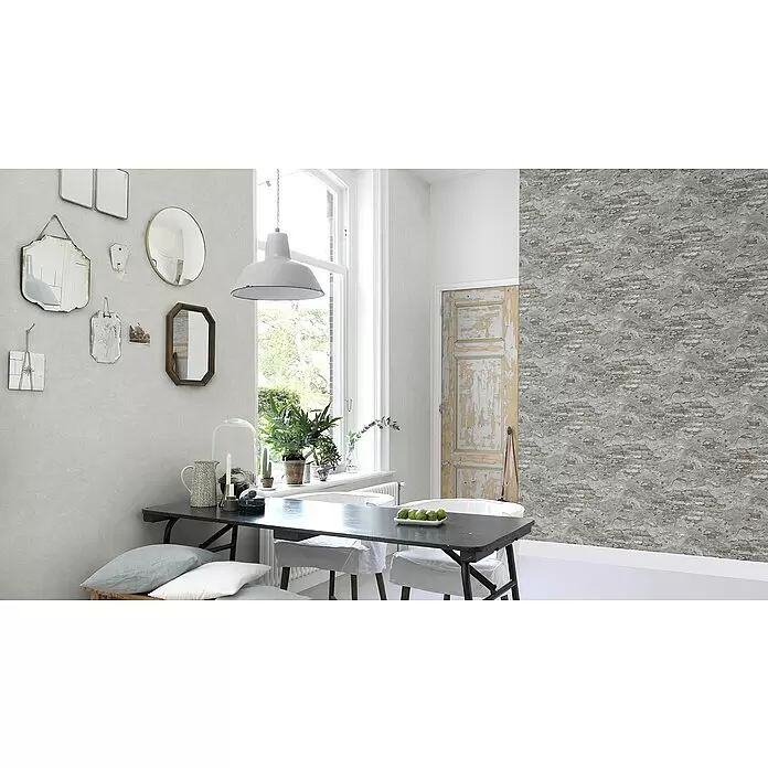 Rasch Vliestapete Bruchstein - Rot/Grau, Steinoptik, 10,05 x 0,53 m - Essbereich mit hellgrauer Struktur-Tapete an einer Wand und freigelegter Ziegel-Beton-Tapete an einer anderen.