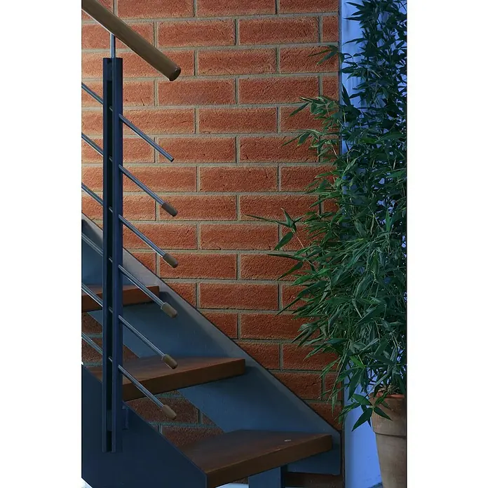 Celina Klinker Verblendstein-Ecke Handform Rotsand - 11,5 cm x 5,2 cm x 7 mm, Rot, Steinoptik - Innenaufnahme mit einem modernen Treppenhaus, Backsteinmauer und einer Zimmerpflanze. Das Treppenhaus besticht durch sein minimalistisches Design.