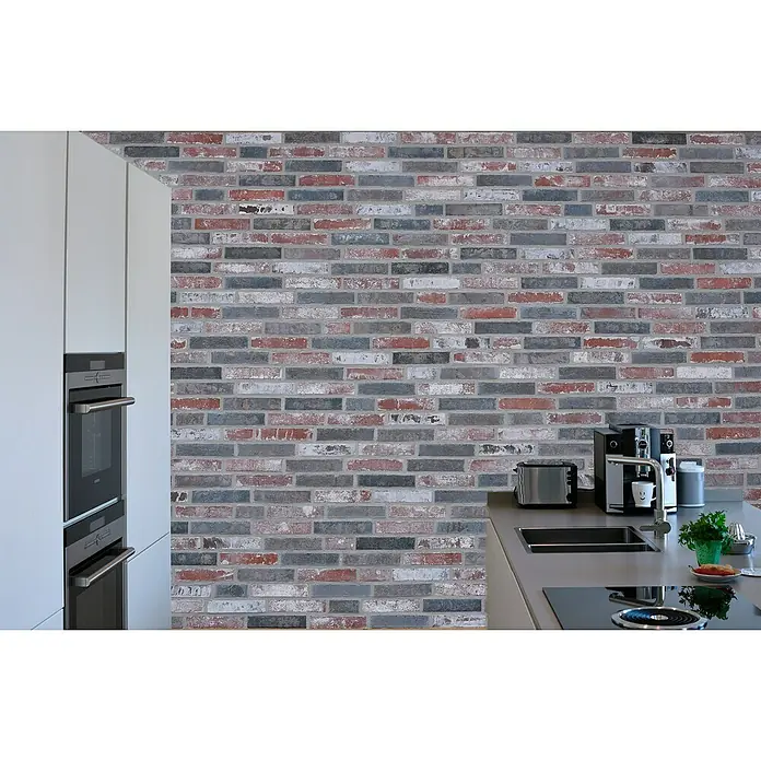 Celina Klinker Verblendstein-Ecke Vintage Malmö - 24 cm x 11,5 cm x 15 mm, Beige/Grau, Steinoptik - Eine moderne Küche mit eingebautem Backofen und einer stilvollen Ziegelwand, die eine elegante Atmosphäre schafft.