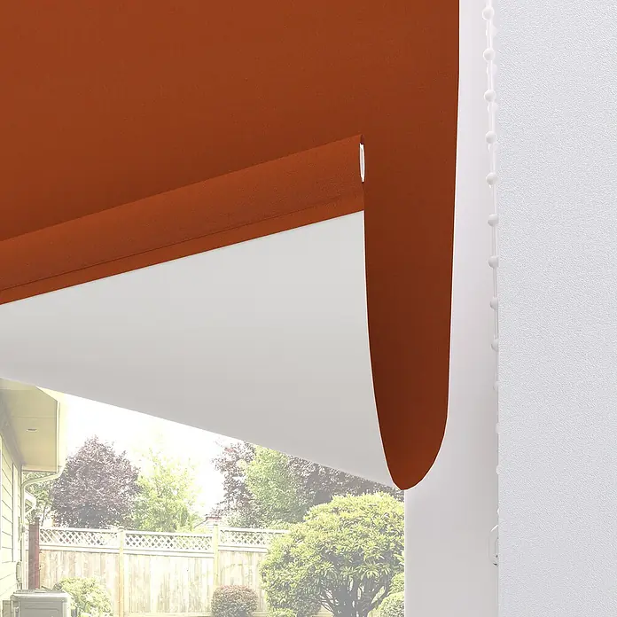 Expo Ambiente VerdunkelungsrolloB x H: 60 x 190 cm, Terracotta, Uni - Nahaufnahme einer stilvollen, orangefarbenen Markise, die Schatten spendet und das Gebäude aufwertet.