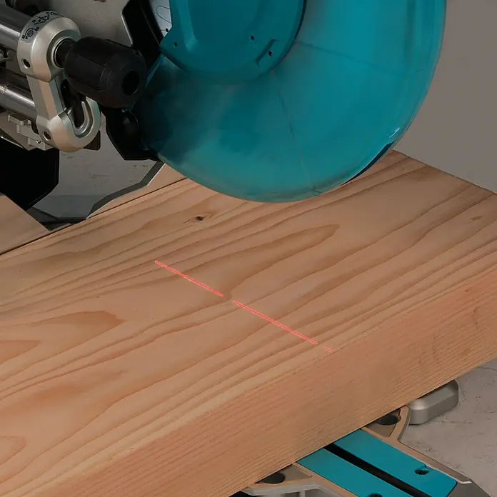 Makita Kapp- & Gehrungssäge LS1219L - 1.800 W, Durchmesser Sägeblatt: 305 mm, Leerlaufdrehzahl: 0 U/min - 3.200 U/min - Eine Tischkreissäge mit Laserführung schneidet ein Holzbrett präzise. Ideal für genaue Holzarbeiten und Heimwerkerprojekte.