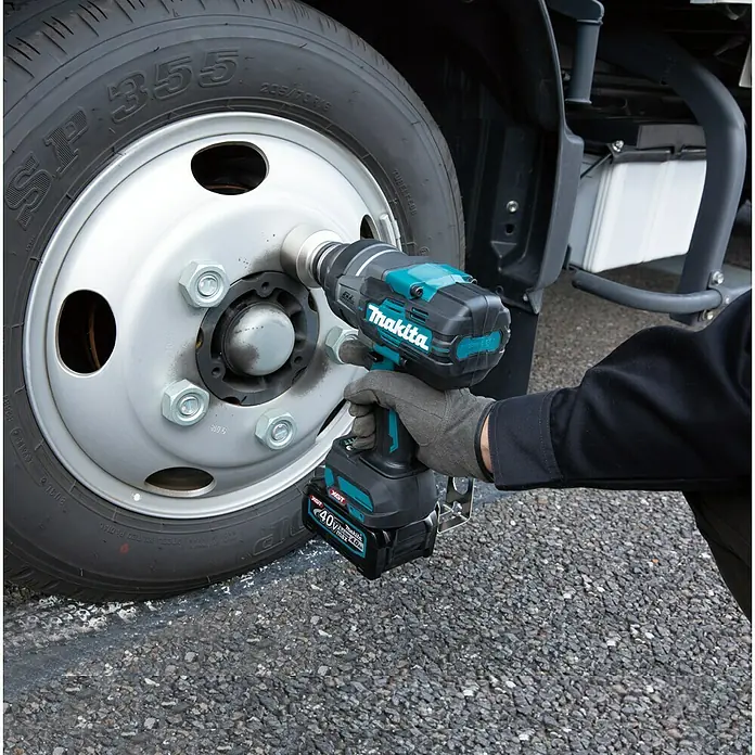 Makita XGT 40V max. Akku-Schlagschrauber TW001GZ - 40 V, Ohne Akku - Nahaufnahme eines Makita-Schlagschraubers beim Anziehen einer Radmutter an einem Lastwagen. Ein unverzichtbares Werkzeug für Profis!
