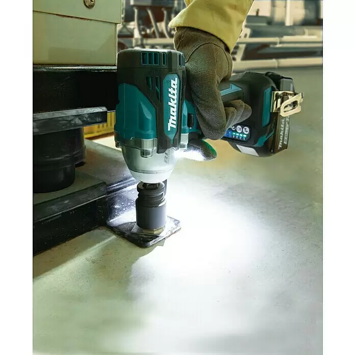 Makita LXT 18V Akku-Schlagschrauber DTW300RTJ - 18 V, 2 Akkus, 5 Ah, 330 Nm, Max. Schlagzahl: 4.000 /min - Makita türkis-schwarzer Akku-Schlagschrauber im Einsatz, von behandschuhter Hand gehalten, zieht einen Bolzen auf Metall fest. Integriertes Licht leuchtet den Arbeitsbereich aus.