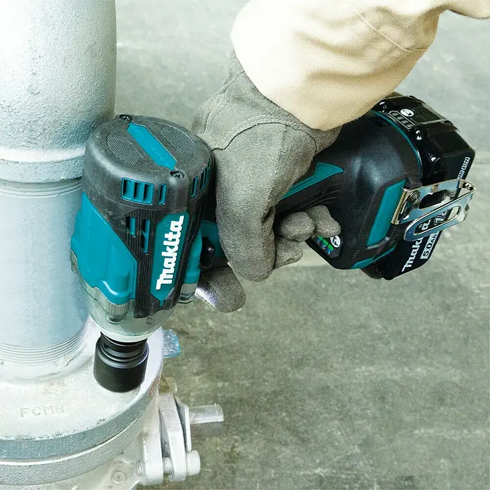 Makita LXT 18V Akku-Schlagschrauber DTW300RTJ - 18 V, 2 Akkus, 5 Ah, 330 Nm, Max. Schlagzahl: 4.000 /min - Nahaufnahme eines Makita Akku-Schlagschraubers, der von einer behandschuhten Hand an einer Metallrohrkonstruktion gehalten wird.