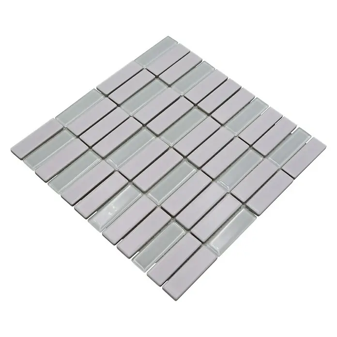 Mosaikfliese Stäbchen Mix ST 325 - 29,7 x 29 cm, Weiß, Matt - Das Bild zeigt ein Mosaikmuster aus rechteckigen, hellgrauen Fliesen, die diagonal auf einer schwarzen Oberfläche angeordnet sind.