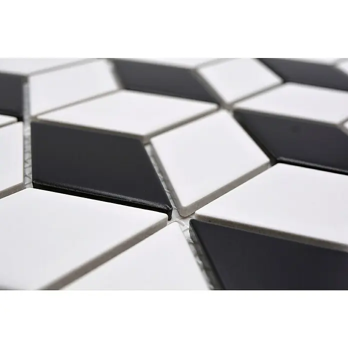 Mosaikfliese Würfel POV 09 - 26,6 x 30,5 cm, Weiß/Schwarz, Matt - Nahaufnahme von schwarz-weißen Mosaikfliesen in Rautenform, die ein geometrisches Muster bilden, ideal für moderne Innendesigns.