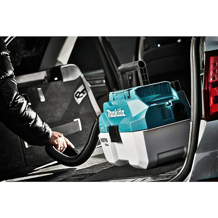 Makita LXT 18V Akku-Nass-Trockensauger DVC750LZX3 - 18 V, Ohne Akku, Behältervolumen: 7,5 l - Eine Nahaufnahme eines Makita Akku-Staubsaugers im Kofferraum eines Autos, der von einer Hand bedient wird, um das Auto zu reinigen.
