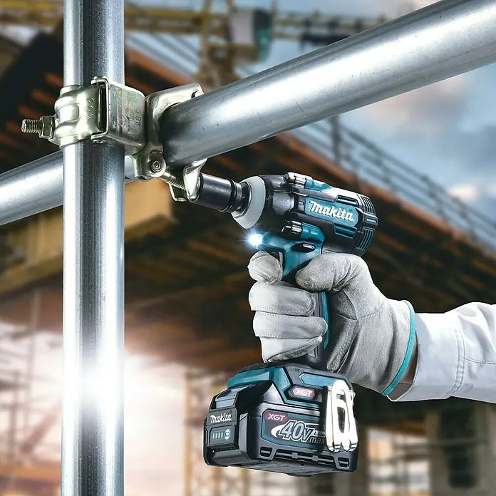 Makita XGT 40V max. Akku-Schlagschrauber TW004GZ - 40 V, Ohne Akku - Ein Makita Akku-Schlagschrauber XGT 40V wird auf einer Baustelle verwendet, um eine Schelle an einem Gerüst zu befestigen.
